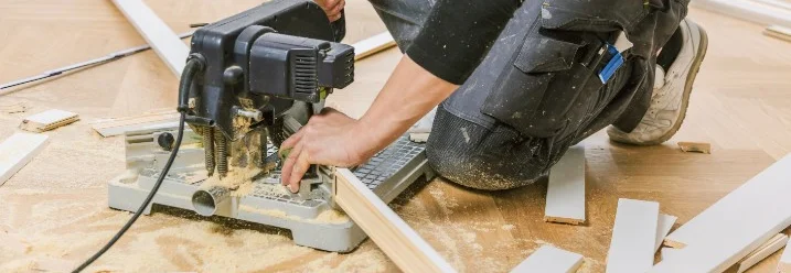 Person schneidet Holzleiste mit Kappsäge